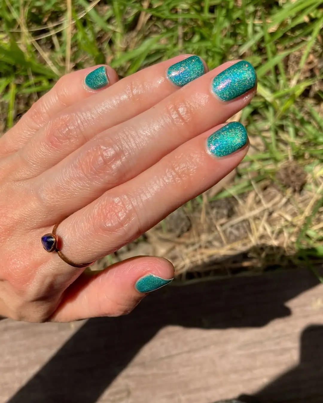 Eye-catching teal nails with sparkling accents