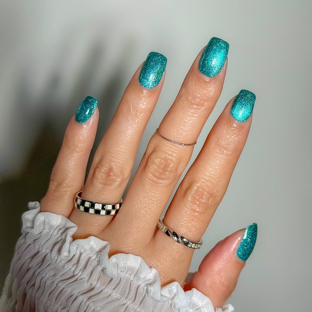 Sparkly teal nails with chic accessories