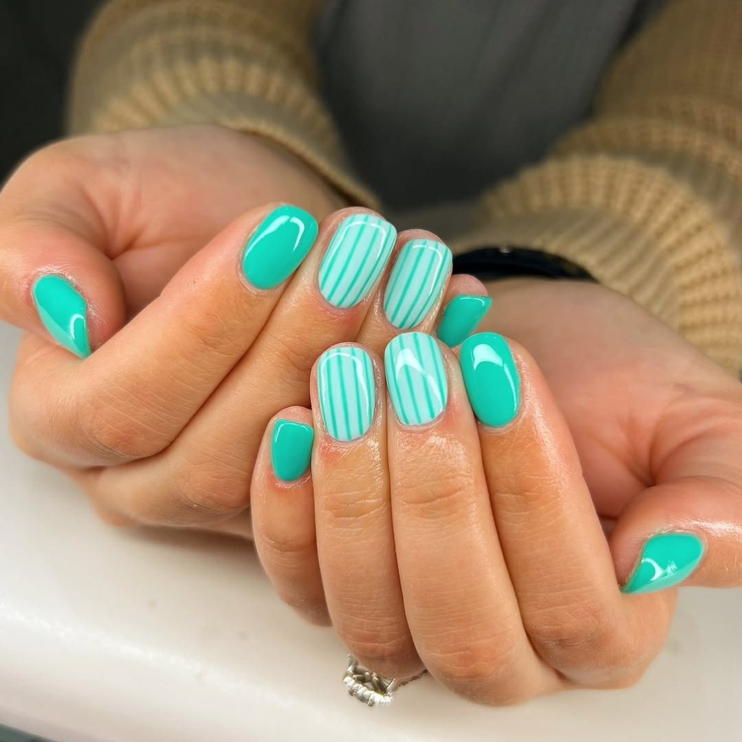 Vibrant teal nails with chic stripes design