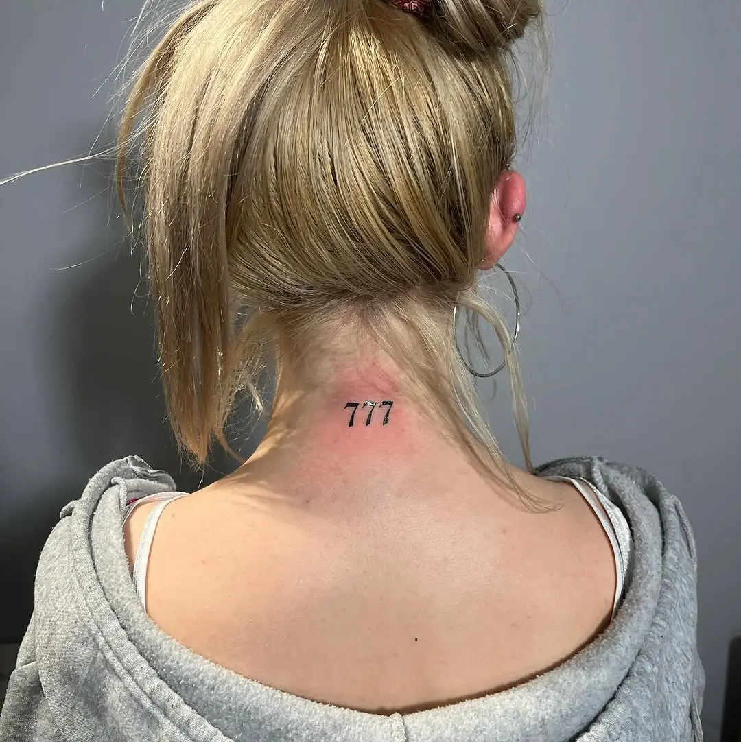 Minimalist 777 Tattoo on Nape of Neck