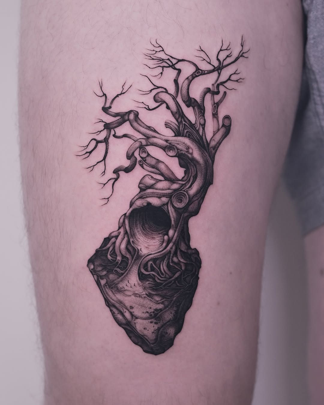 Stunning black ink tree tattoo on thigh