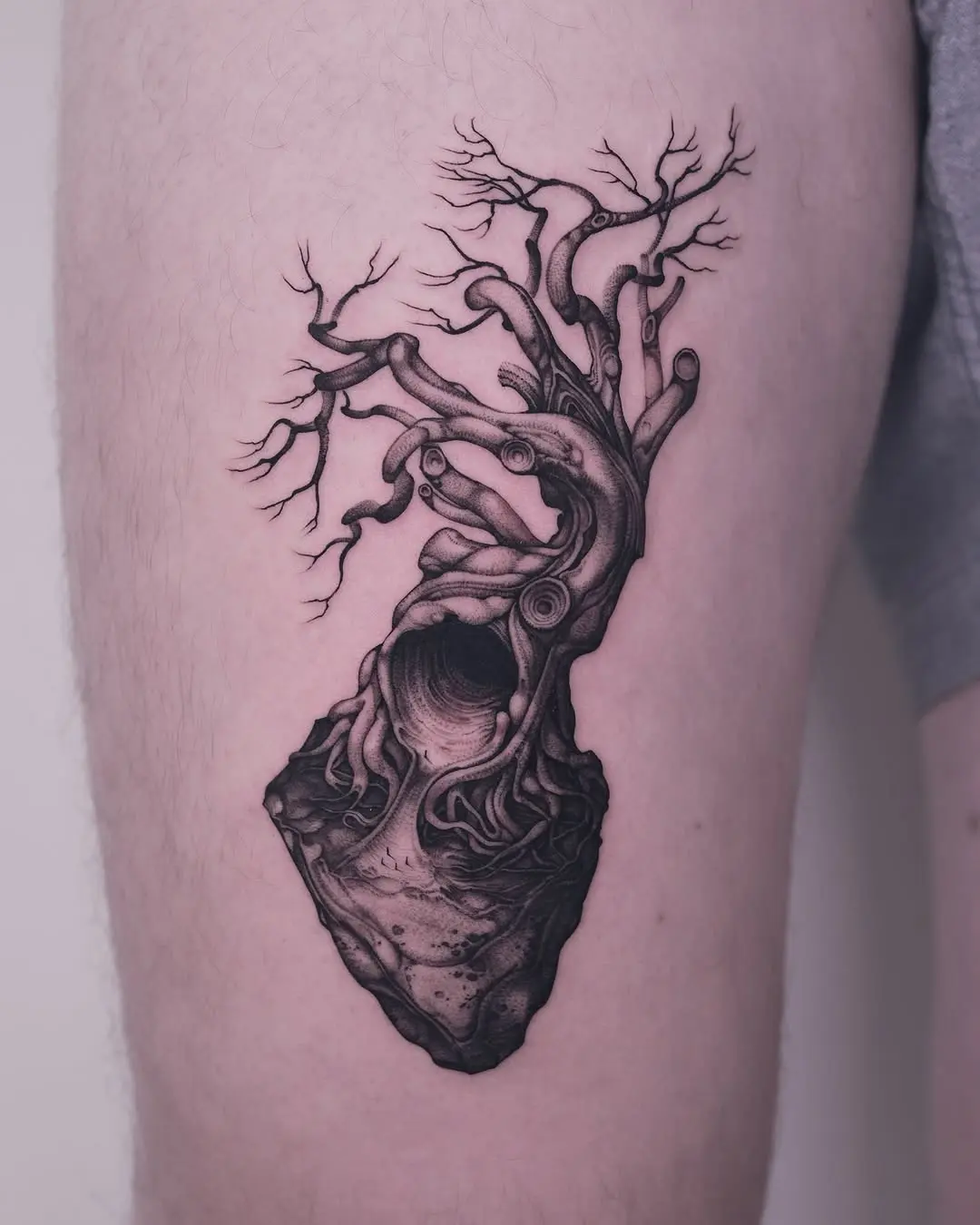 Stunning black ink tree tattoo on thigh