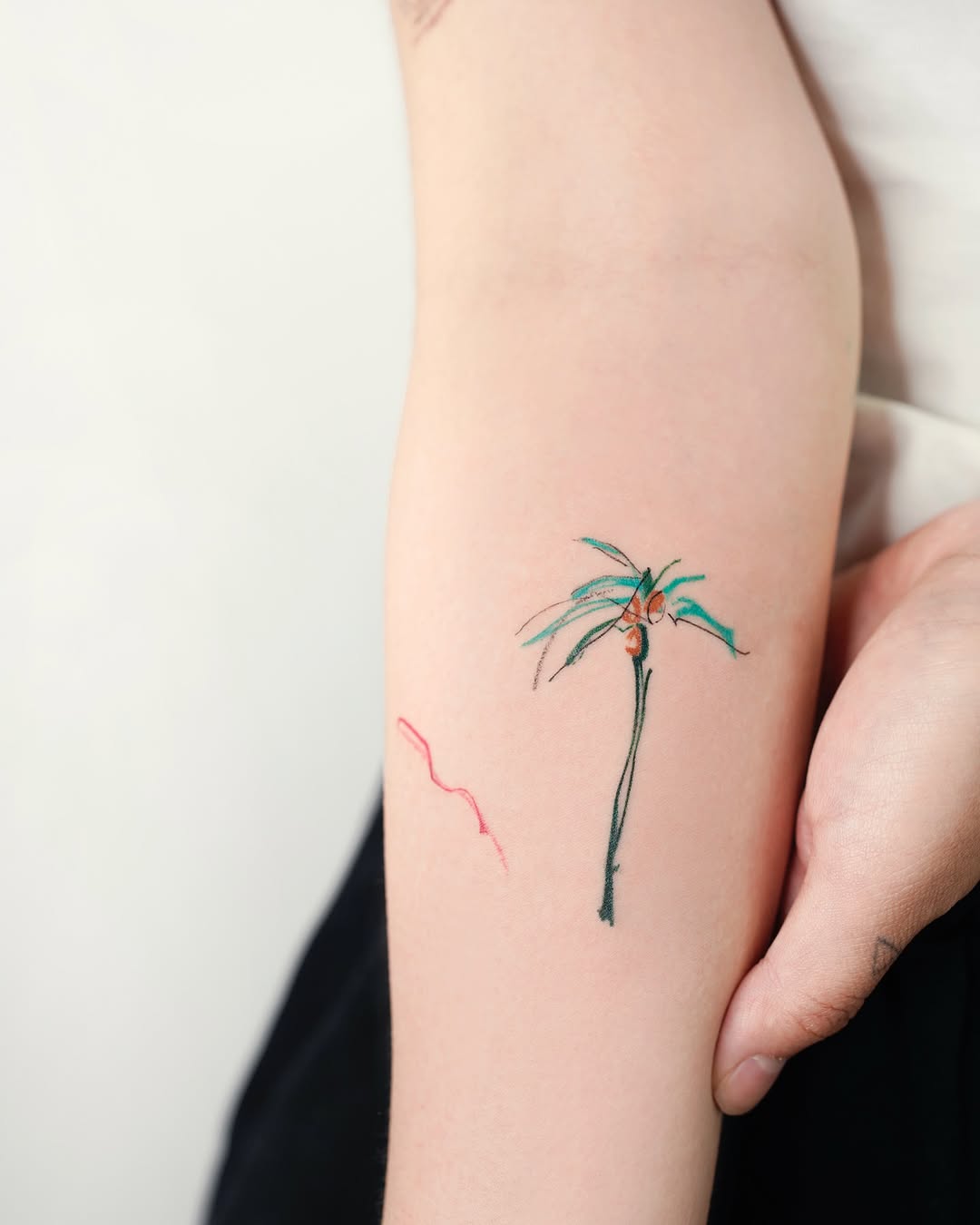 A delicate palm tree tattoo with vibrant colors