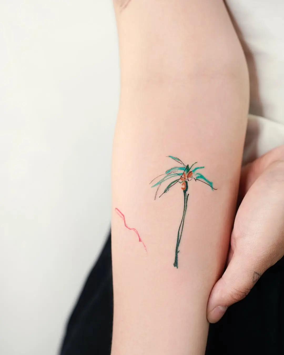 A delicate palm tree tattoo with vibrant colors