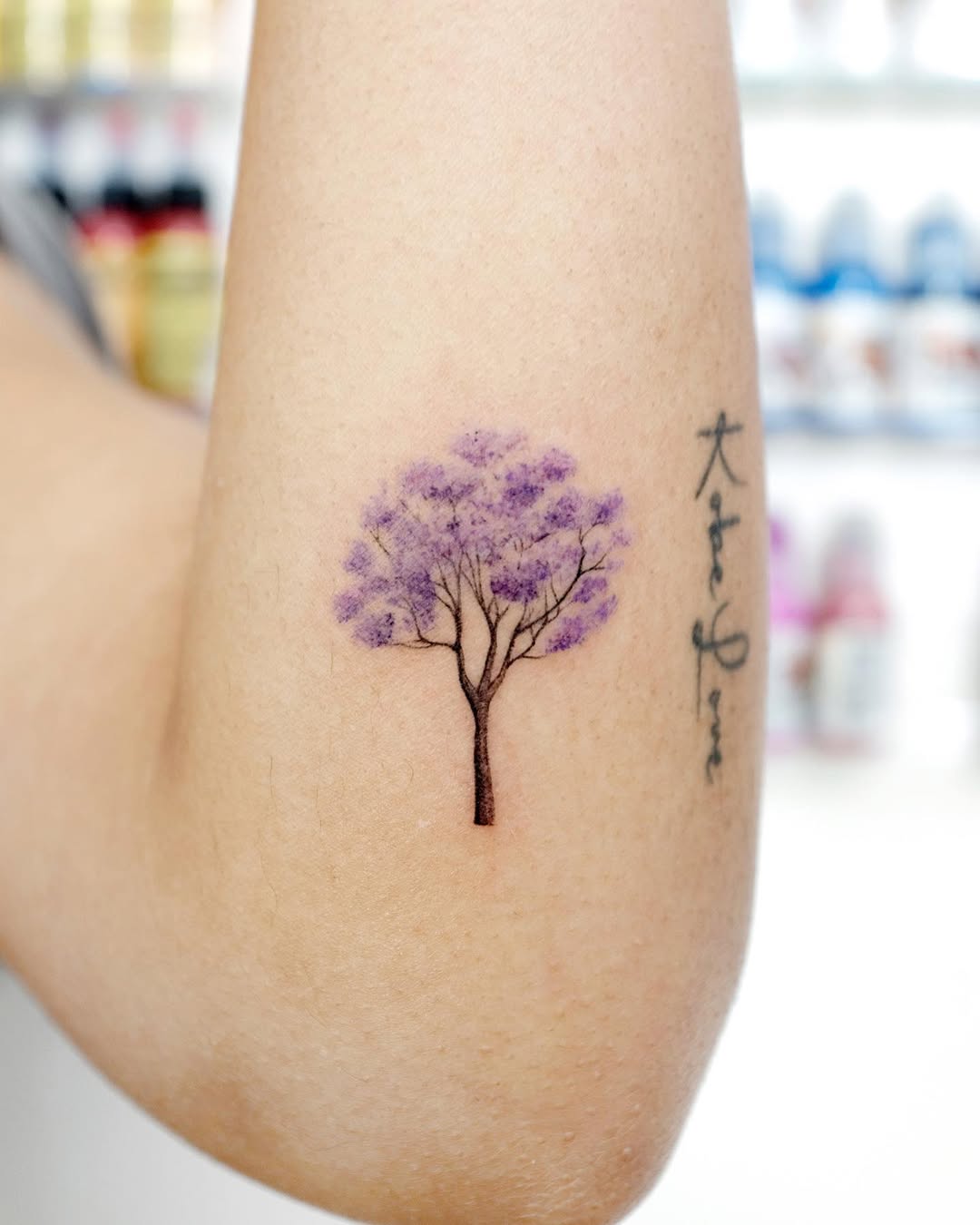 Delicate purple tree tattoo on forearm