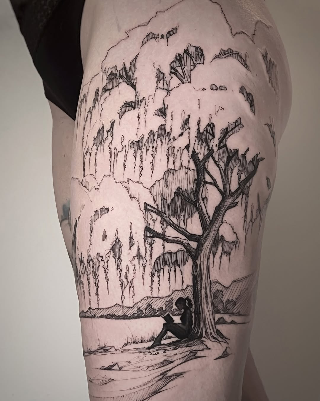 Silhouette resting under a detailed tree tattoo