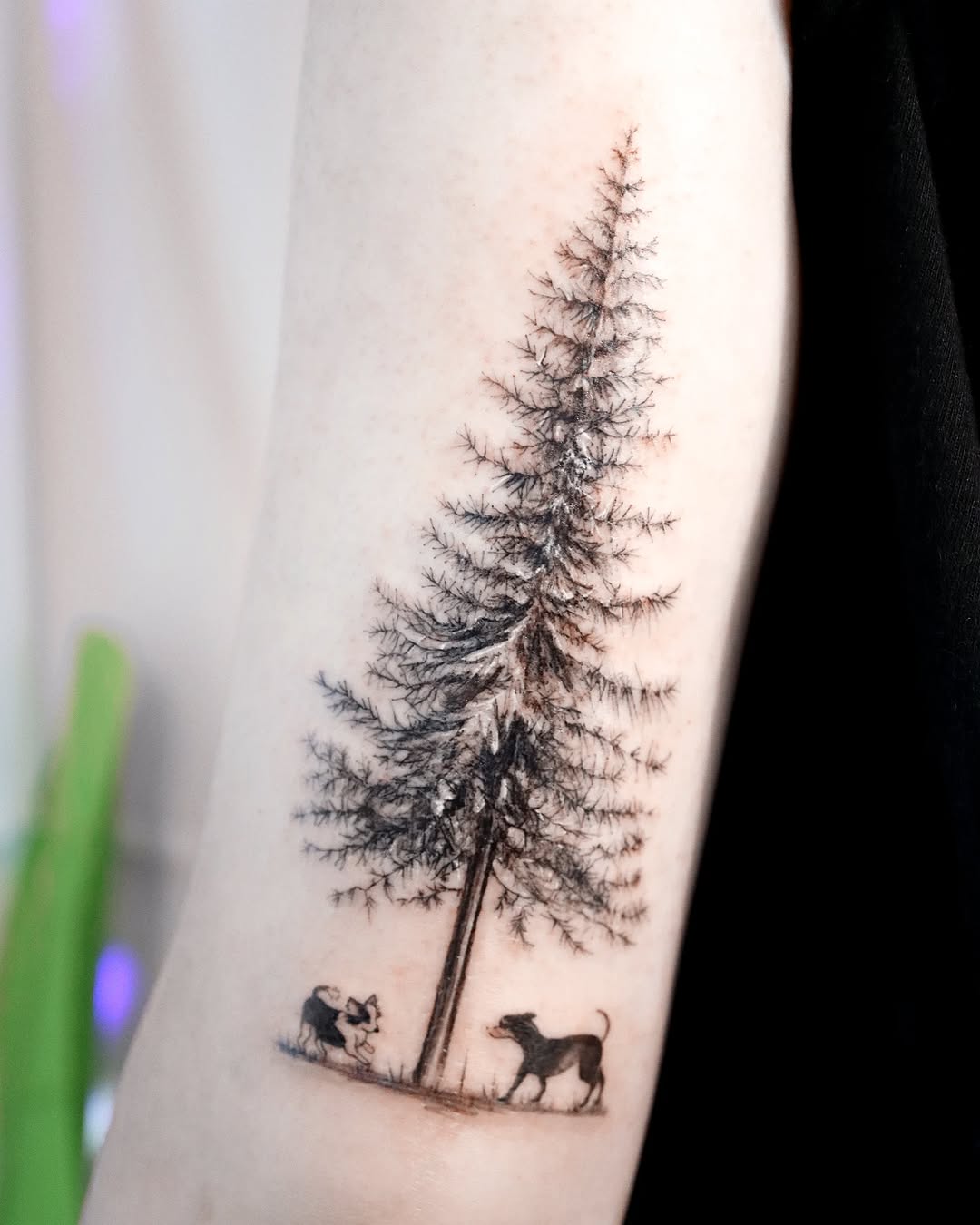 Nature-inspired tree tattoo with playful dogs