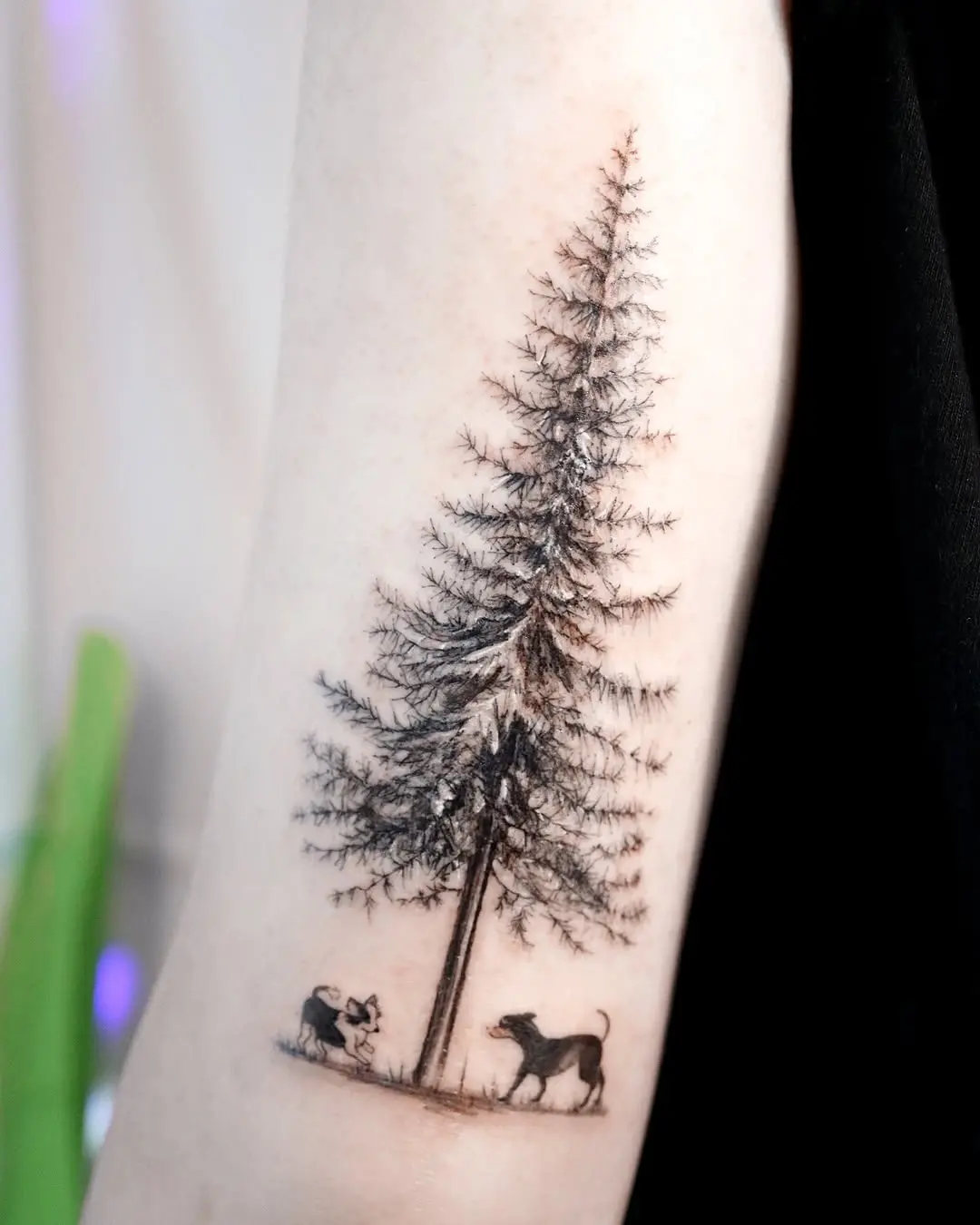 Nature-inspired tree tattoo with playful dogs