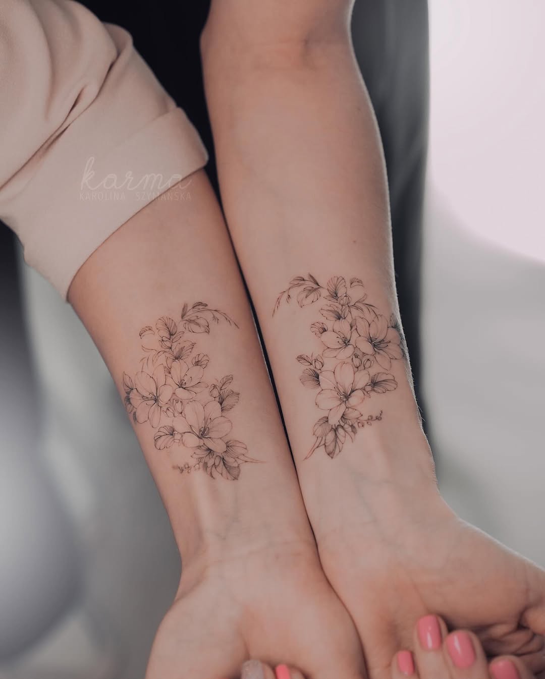 Beautiful twin floral tattoos enhancing sisterly bonds