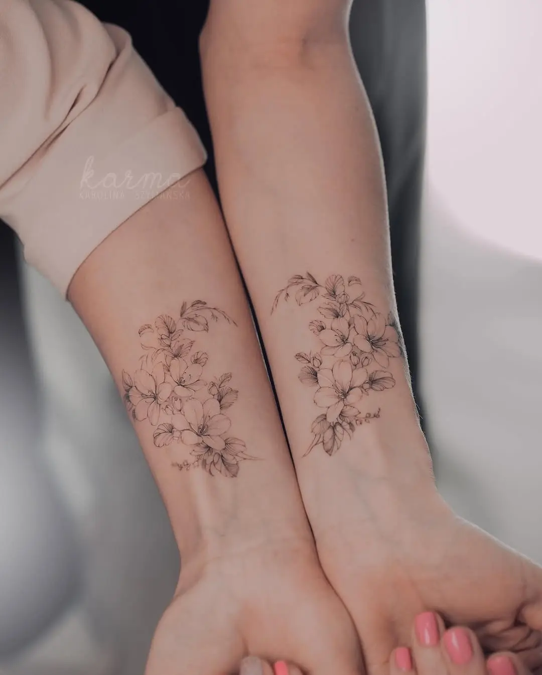 Beautiful twin floral tattoos enhancing sisterly bonds