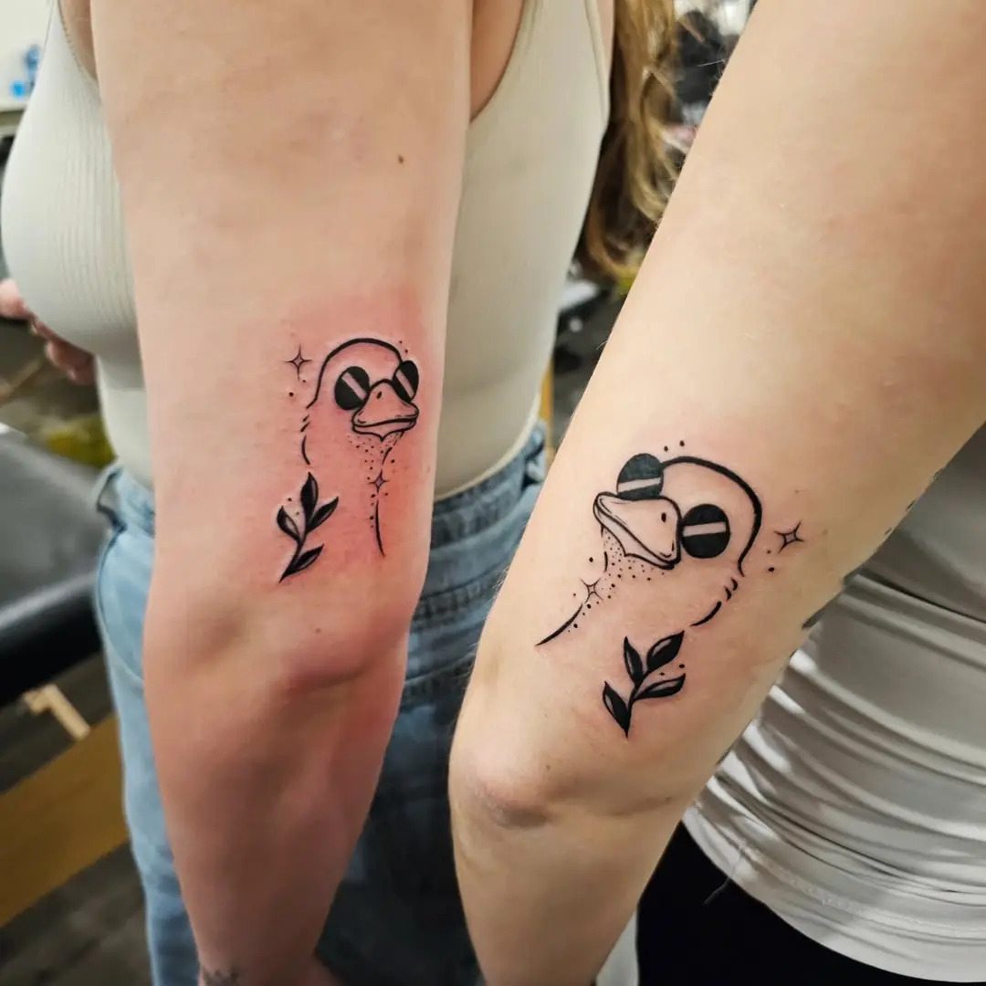 Charming matching duck tattoos for twins