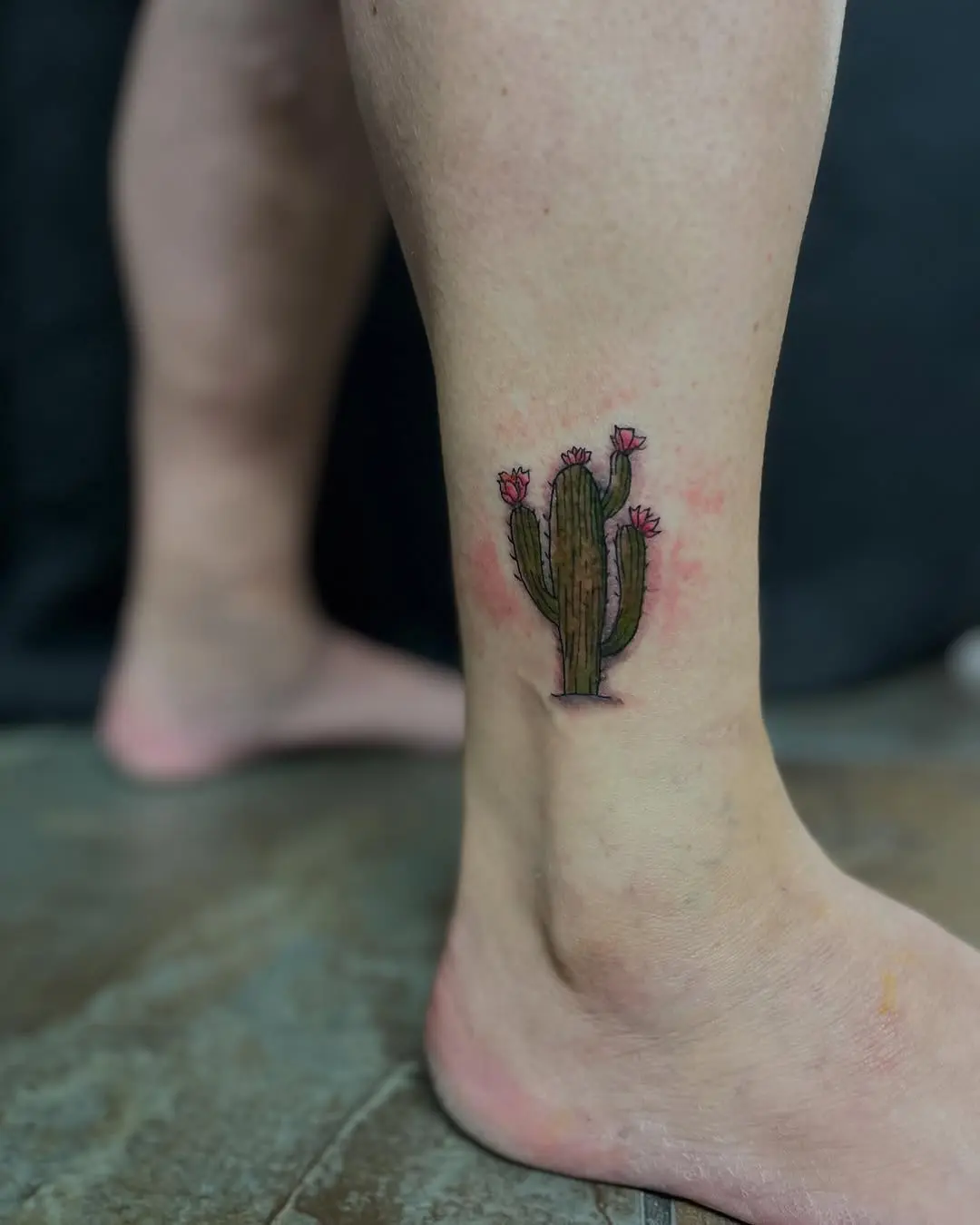 Whimsical cactus tattoo with blooming flowers