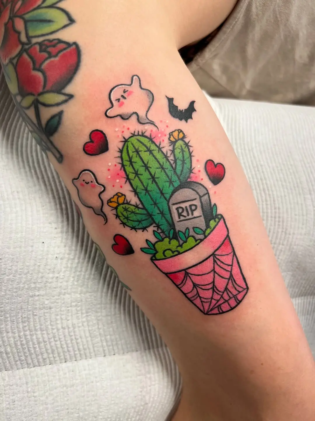 Whimsical cactus tattoo with playful ghosts