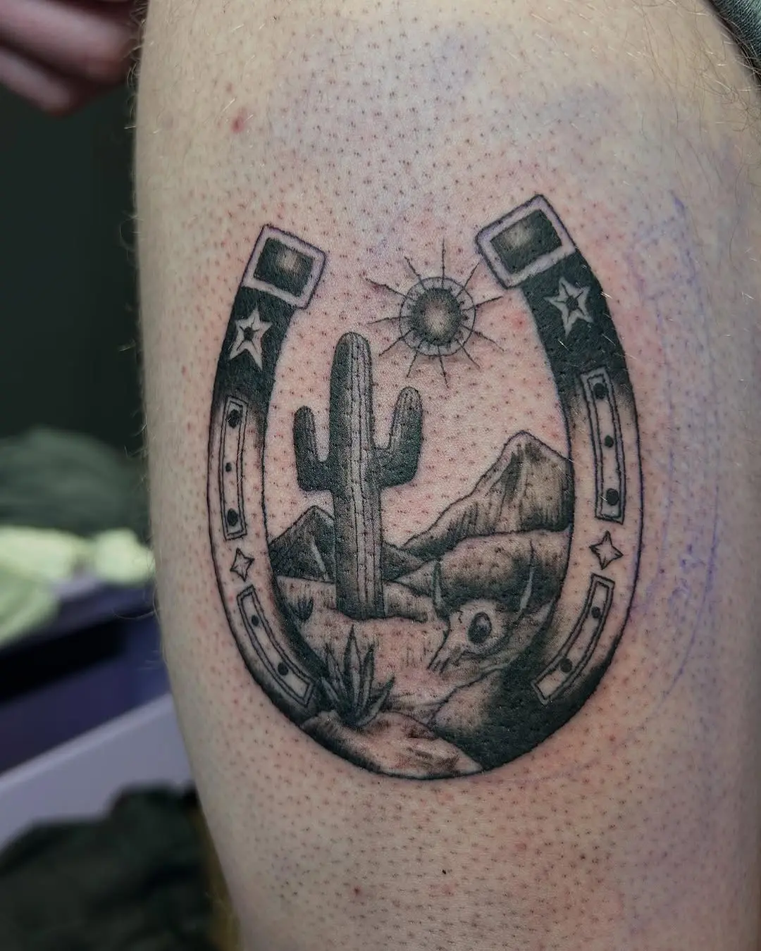 Cactus and horseshoe tattoo with a sunset vibe