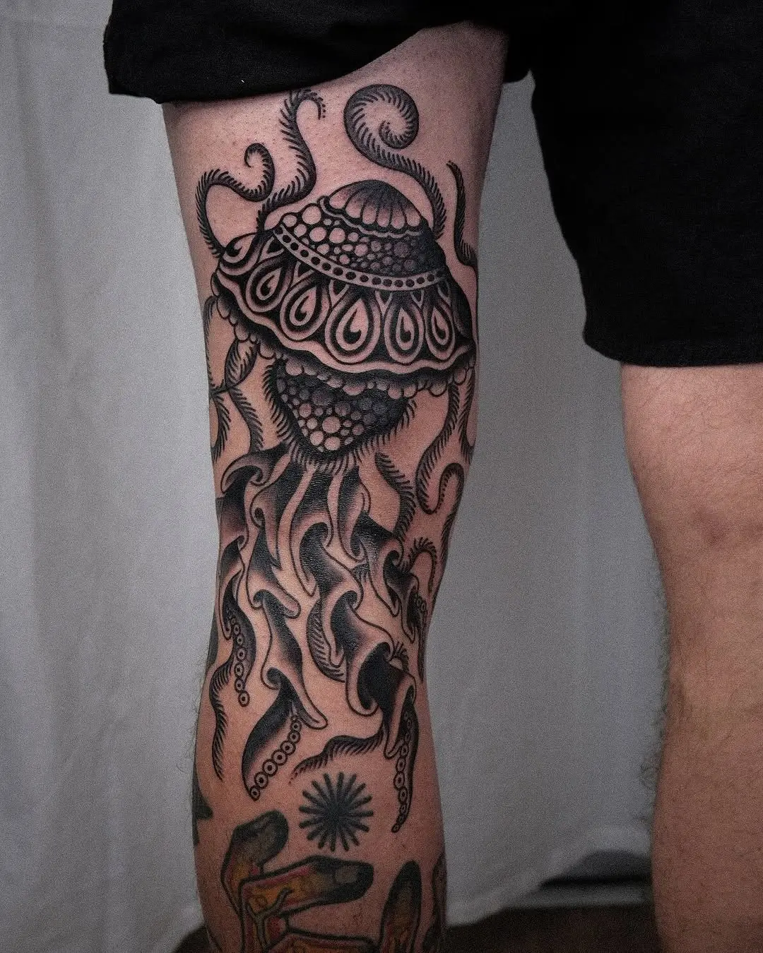 Elegant black ink jellyfish tattoo on leg