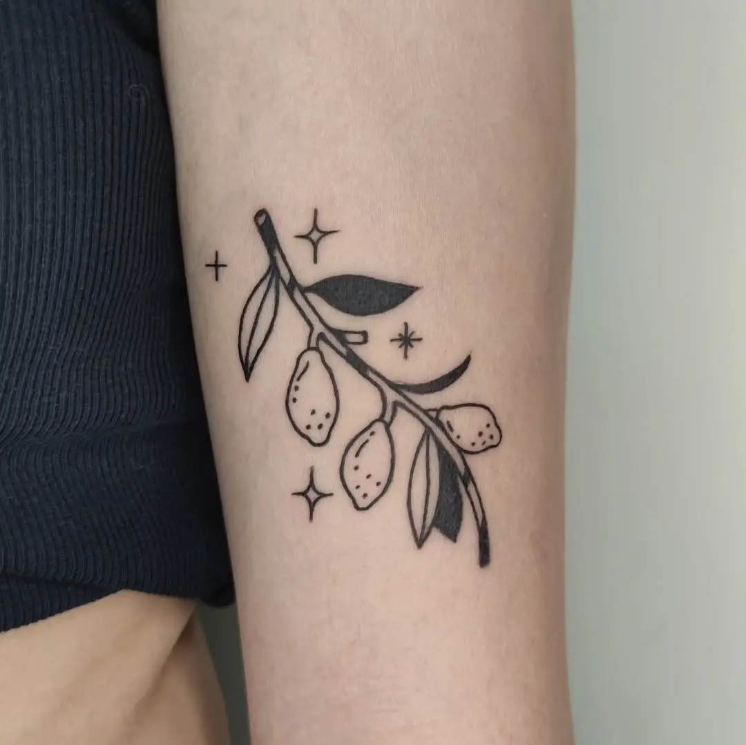 Minimalist lemon branch tattoo with delicate leaves