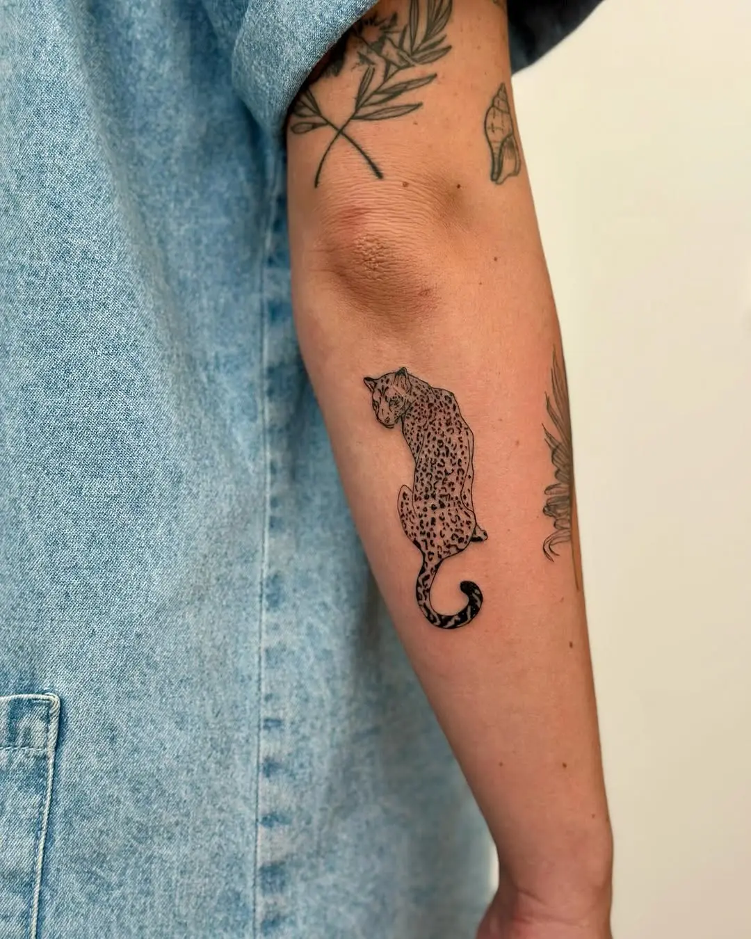 Stylish leopard tattoo on a forearm