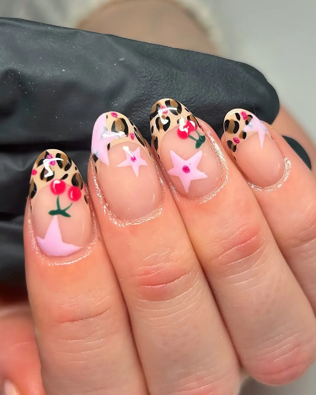 Vibrant leopard nails with cherry and stars