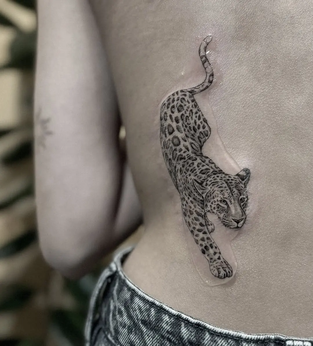 Elegant minimalist leopard tattoo on the arm