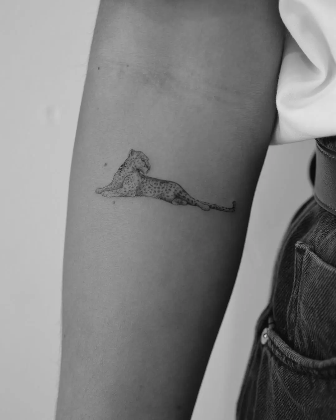Elegant minimalist leopard tattoo on the arm