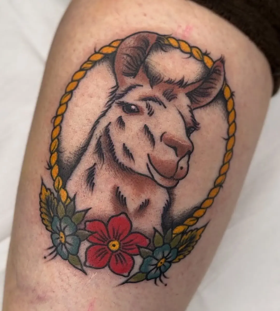 Colorful llama tattoo with floral accents