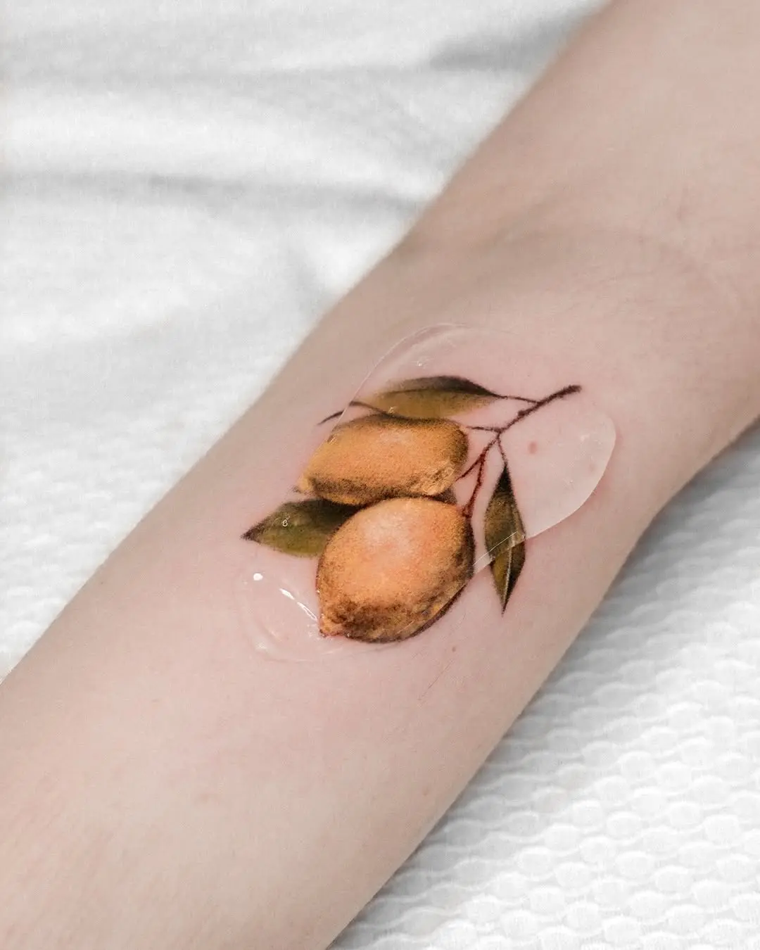 Beautifully detailed lemon tattoo with vibrant colors.