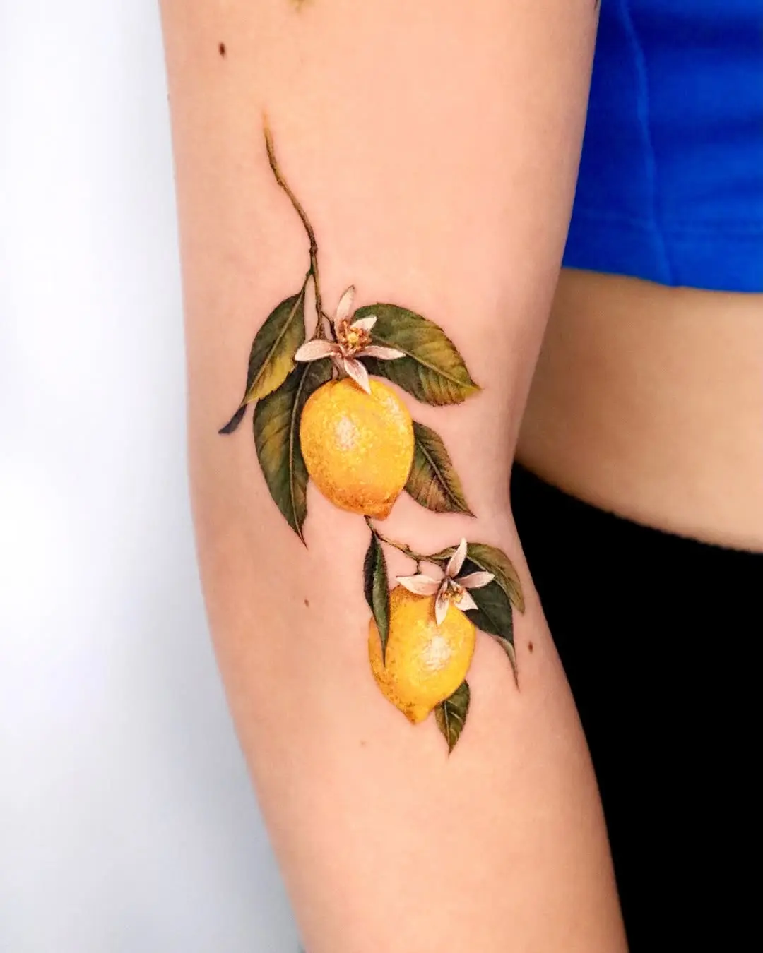 Vibrant lemon tattoo with floral accents
