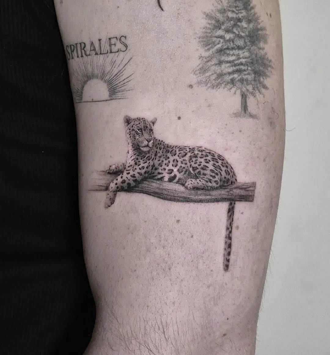 Charming leopard tattoo resting on a branch