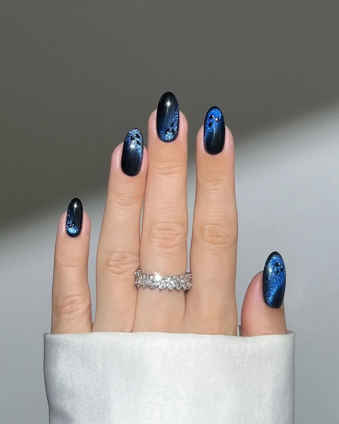 Elegant dark nails with shimmering blue accents