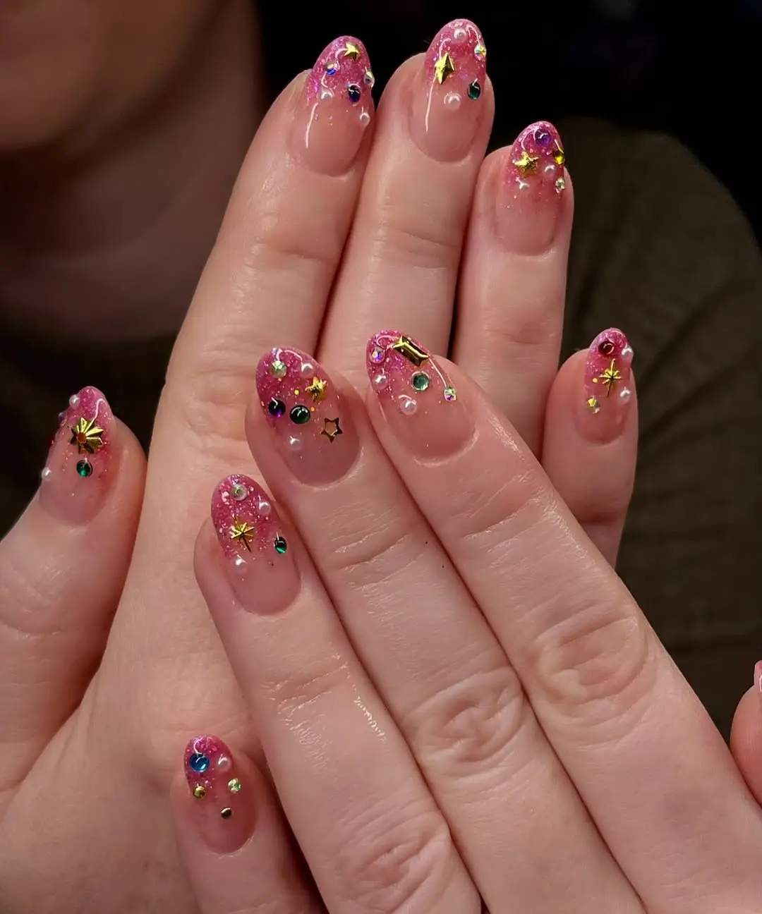 Vibrant pink sparkly nail art with embellishments