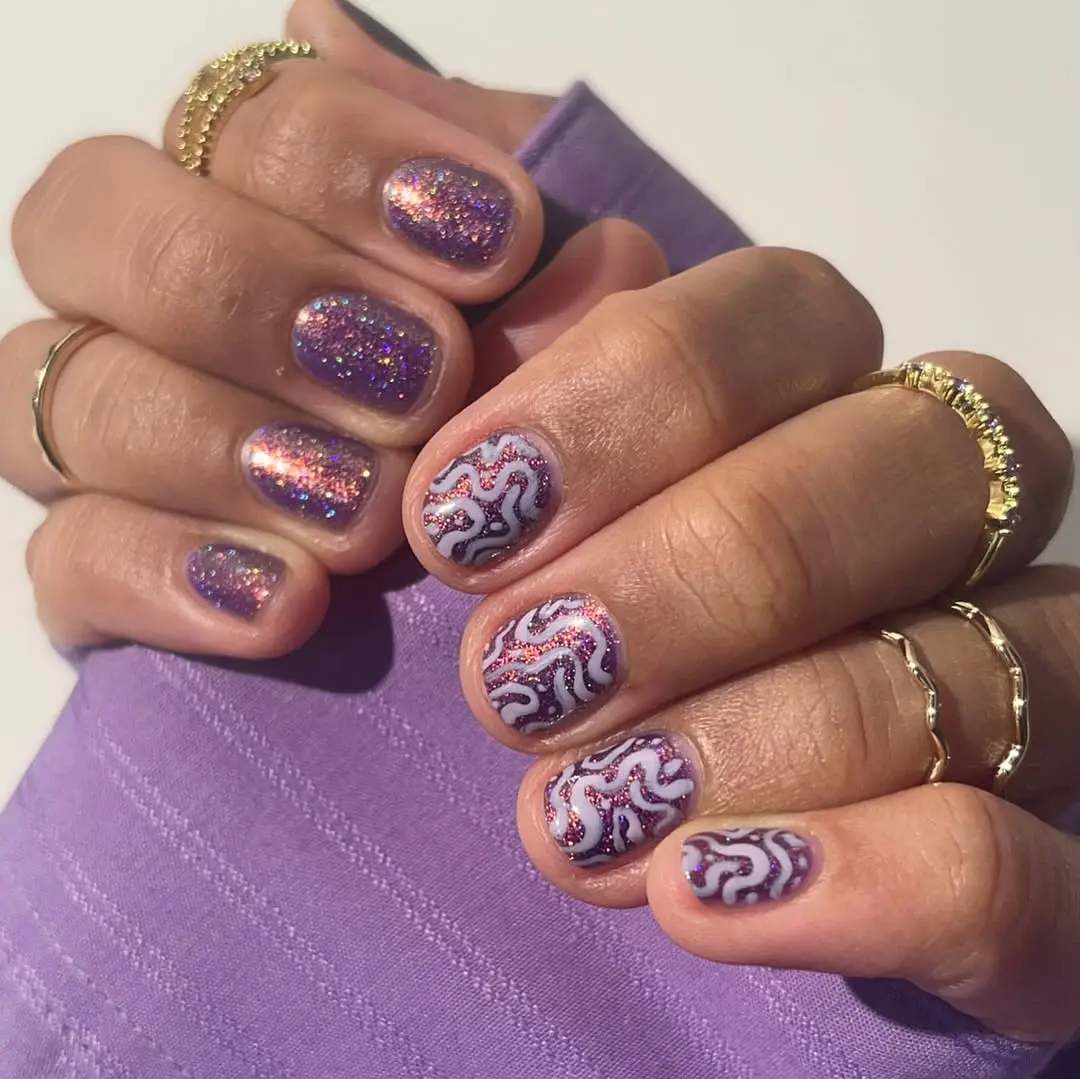 Vibrant purple glitter with unique nail art design
