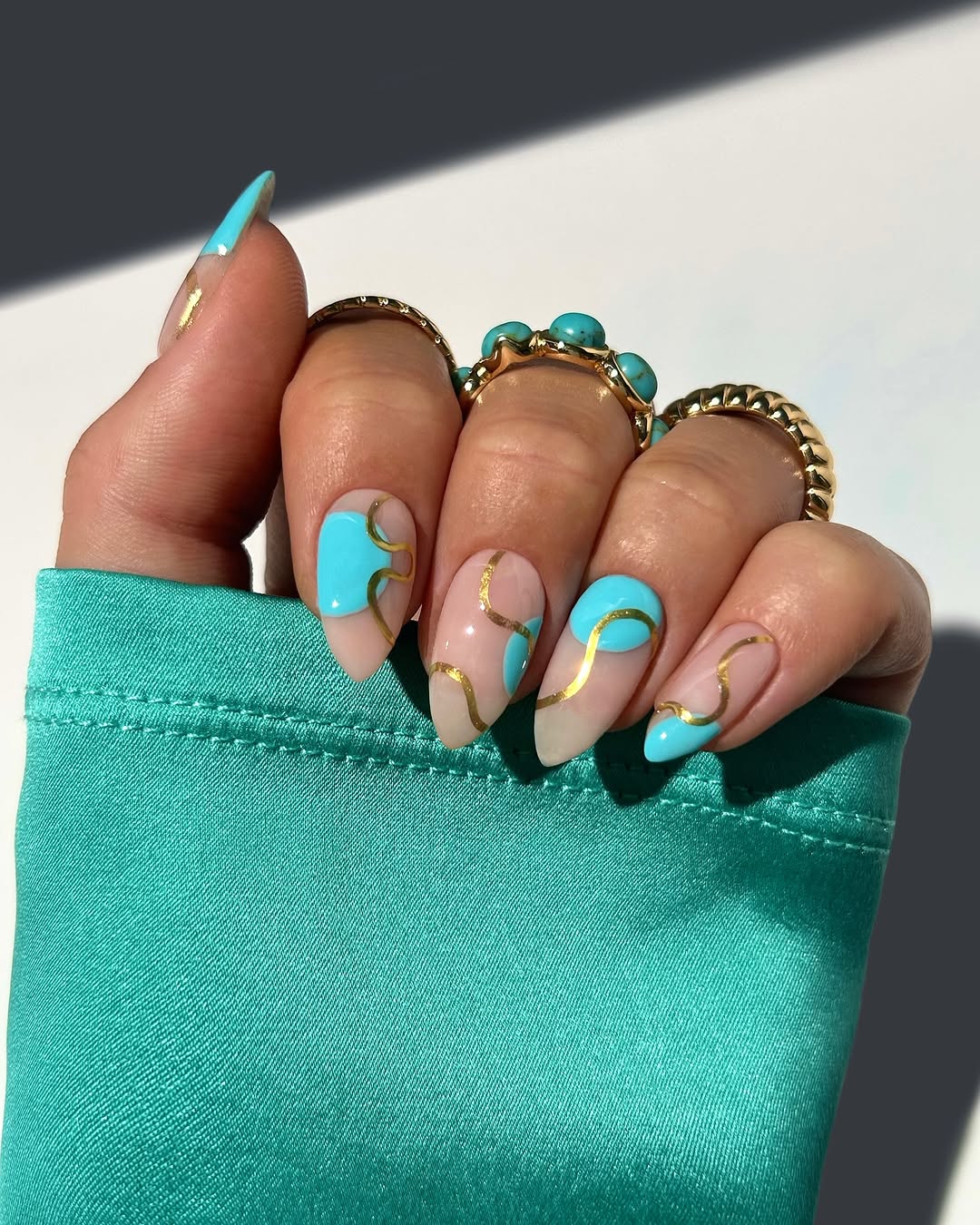 Vibrant aqua summer nails with gold accents
