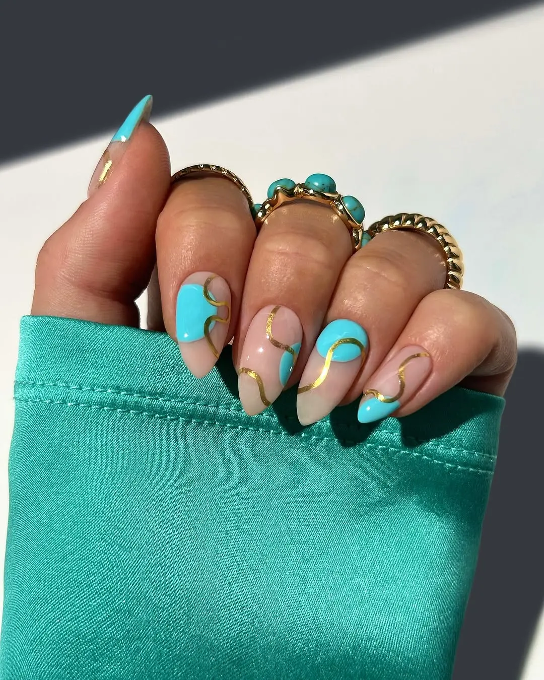 Vibrant aqua summer nails with gold accents