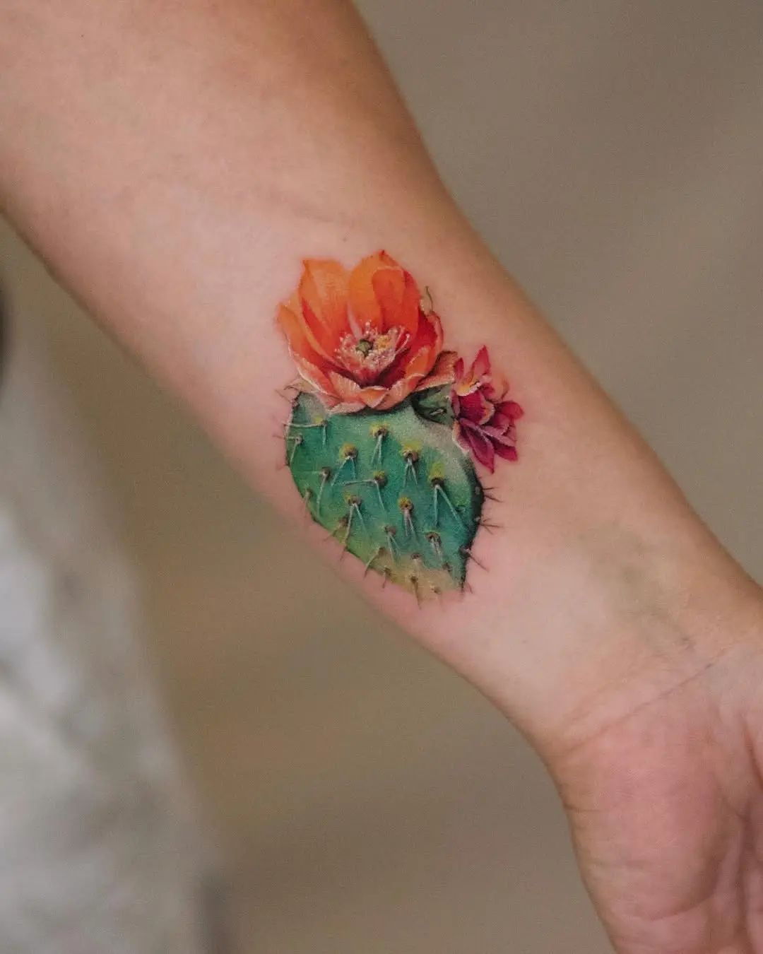Stylish cactus tattoo with vibrant flower