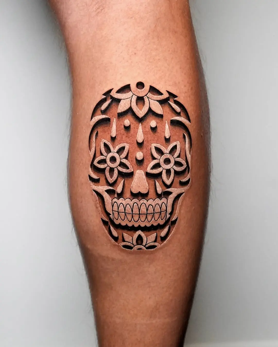 Bold 3D skull tattoo with floral elements