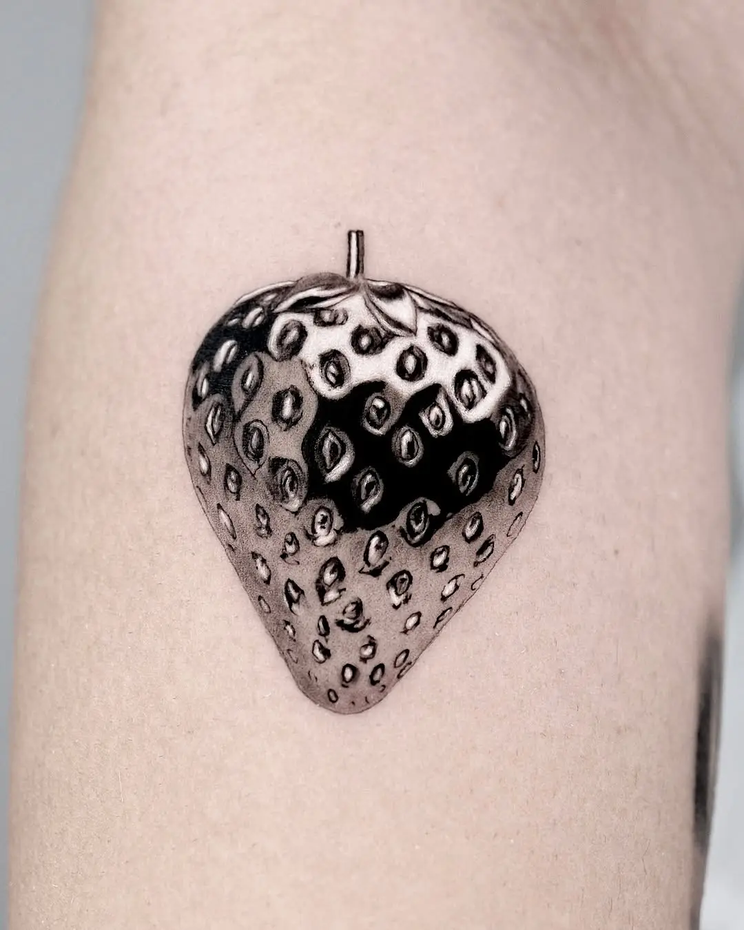 Intricate 3D strawberry tattoo on skin