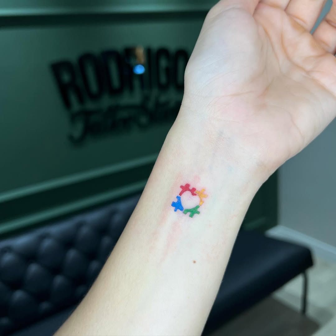 Colorful autism symbols on wrist tattoo
