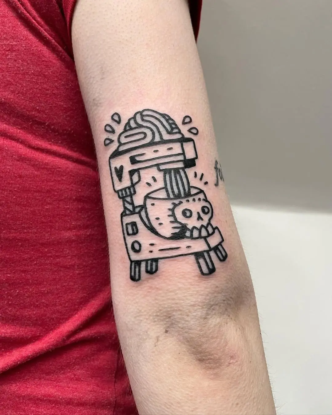 Whimsical baking machine tattoo with a skull