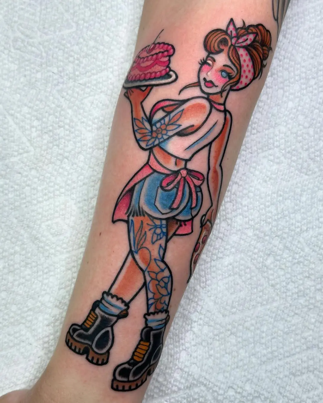Whimsical pinup girl holding a cake tattoo
