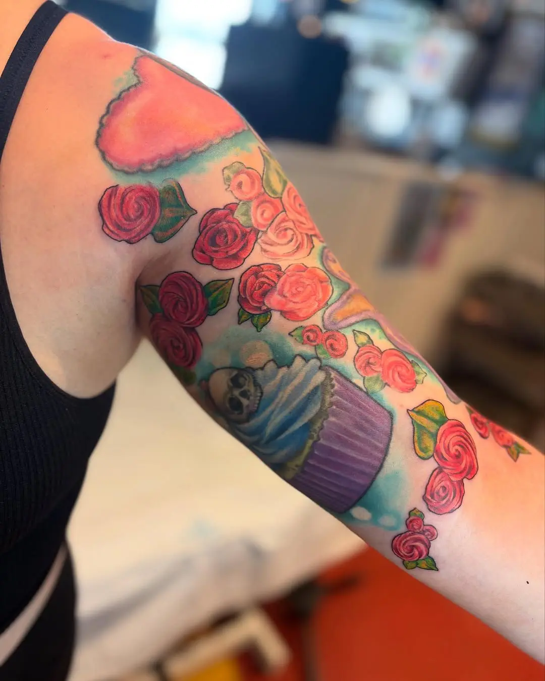Colorful baking-themed floral tattoo on arm