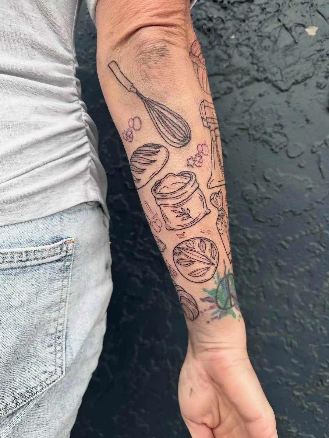 Creative baking-themed tattoos on forearm
