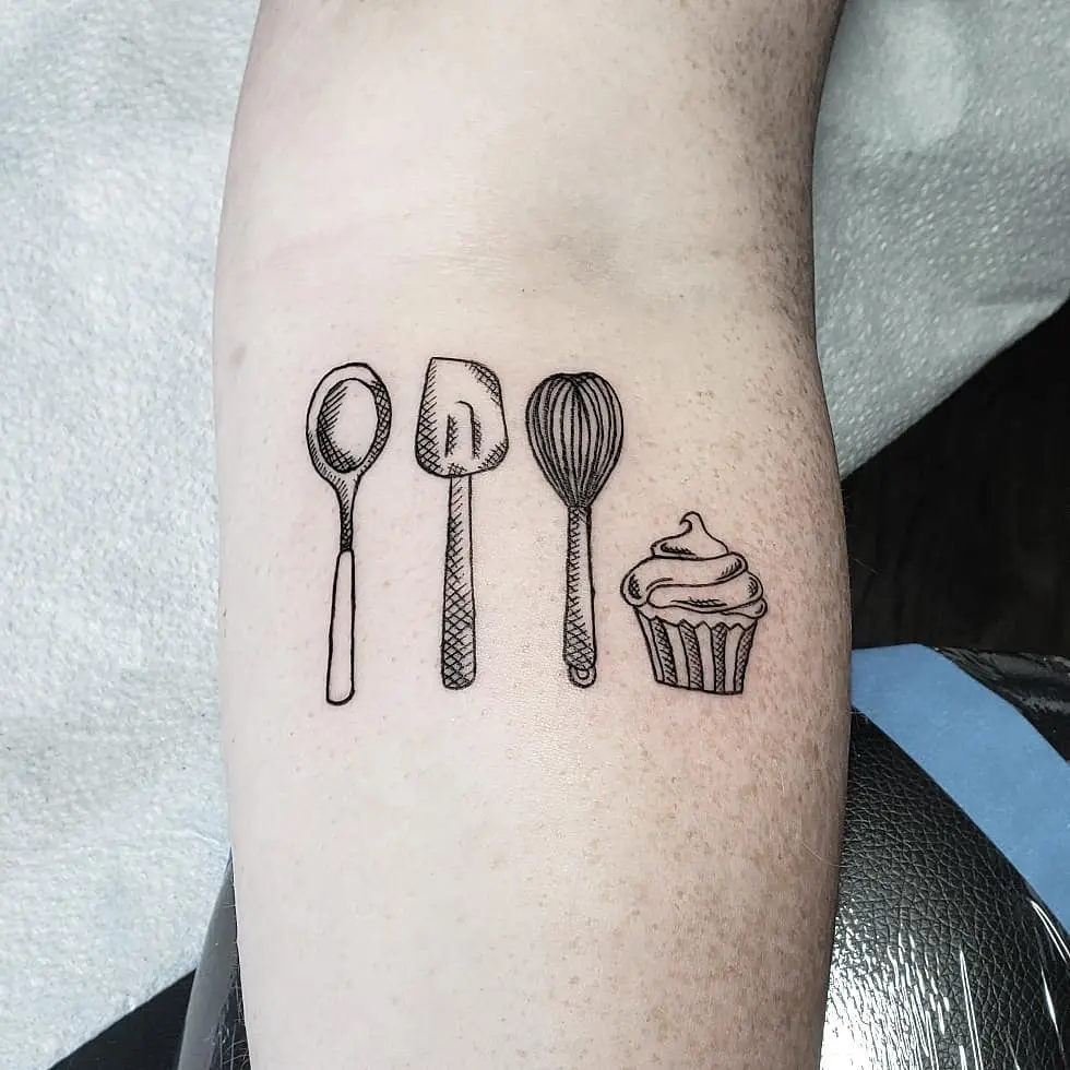 Charming baking-themed tattoo with utensils and cupcake