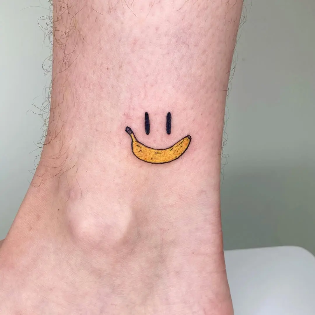 Charming banana smiley tattoo on ankle