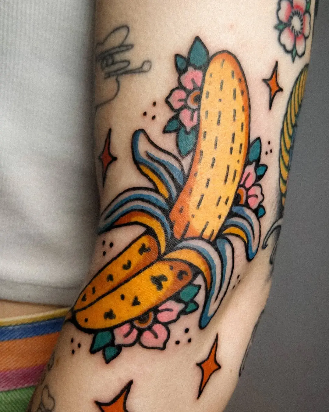 Colorful banana tattoo with floral accents