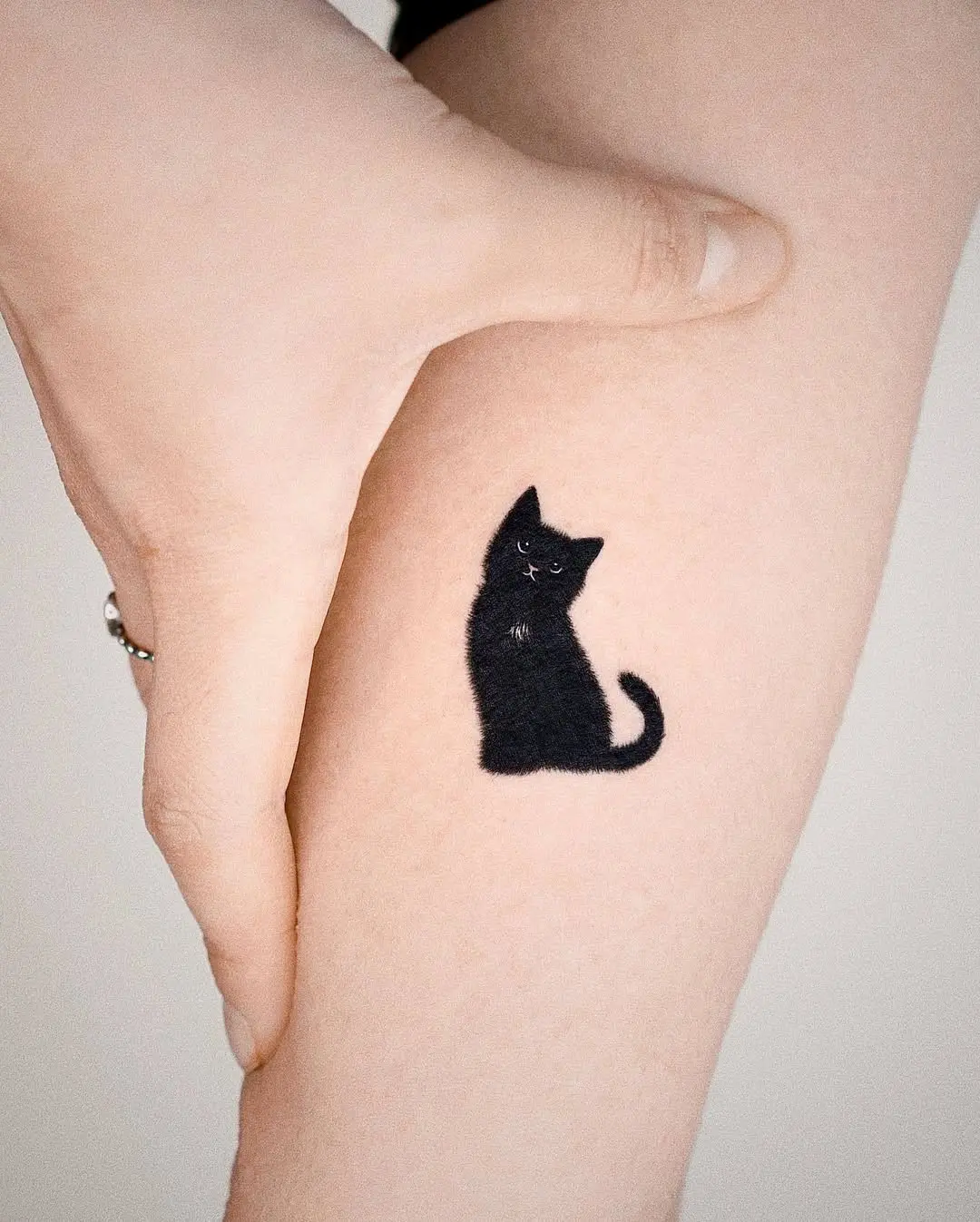 Charming black cat tattoo design on arm