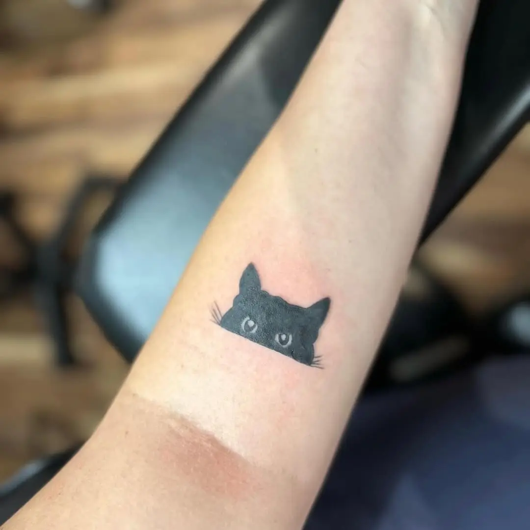 Charming minimalist black cat tattoo design