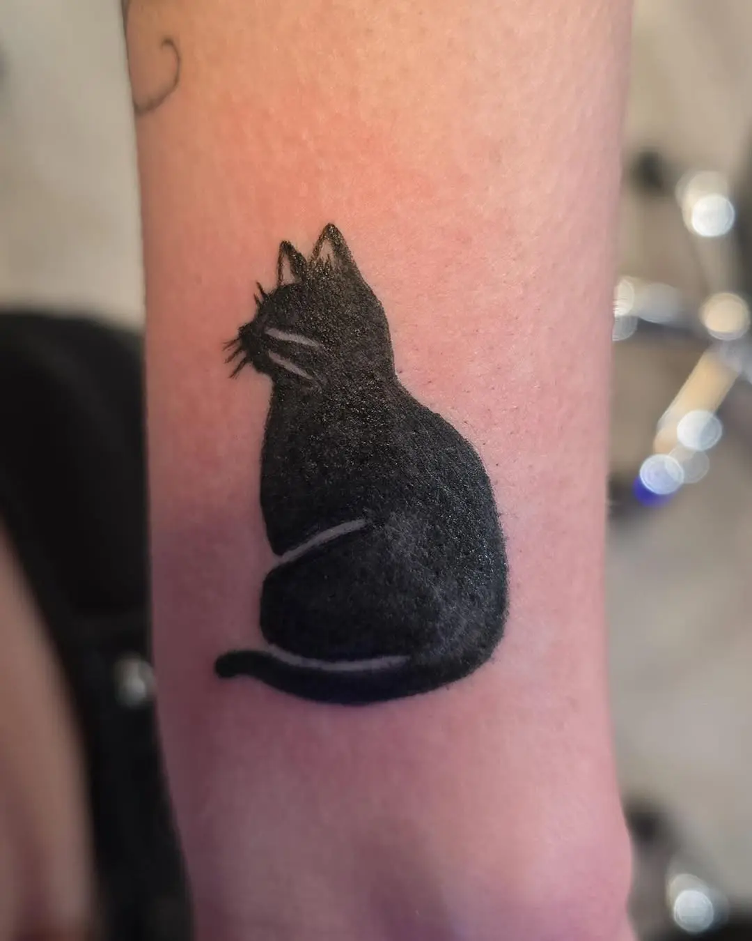 Elegant silhouette of a black cat tattoo