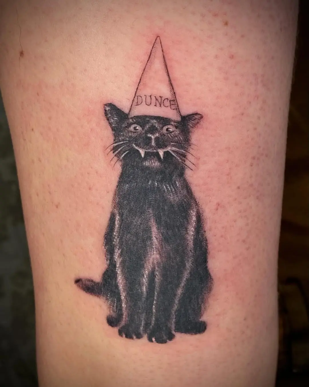 Stylish black cat tattoo with dunce cap
