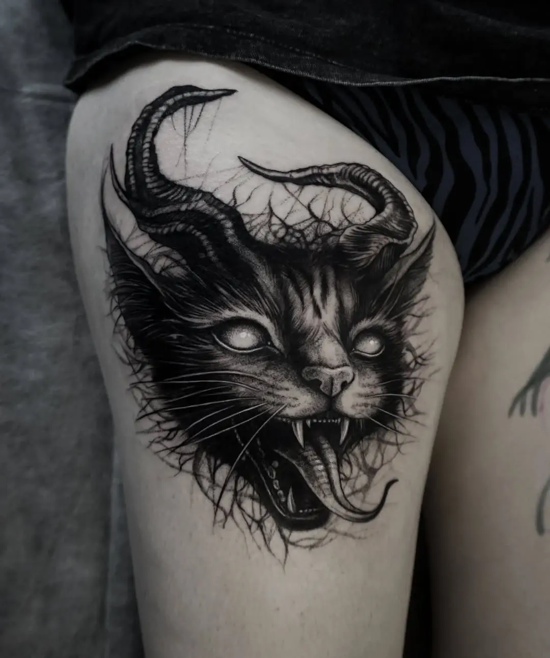 Intricate black cat with mystical horns tattoo