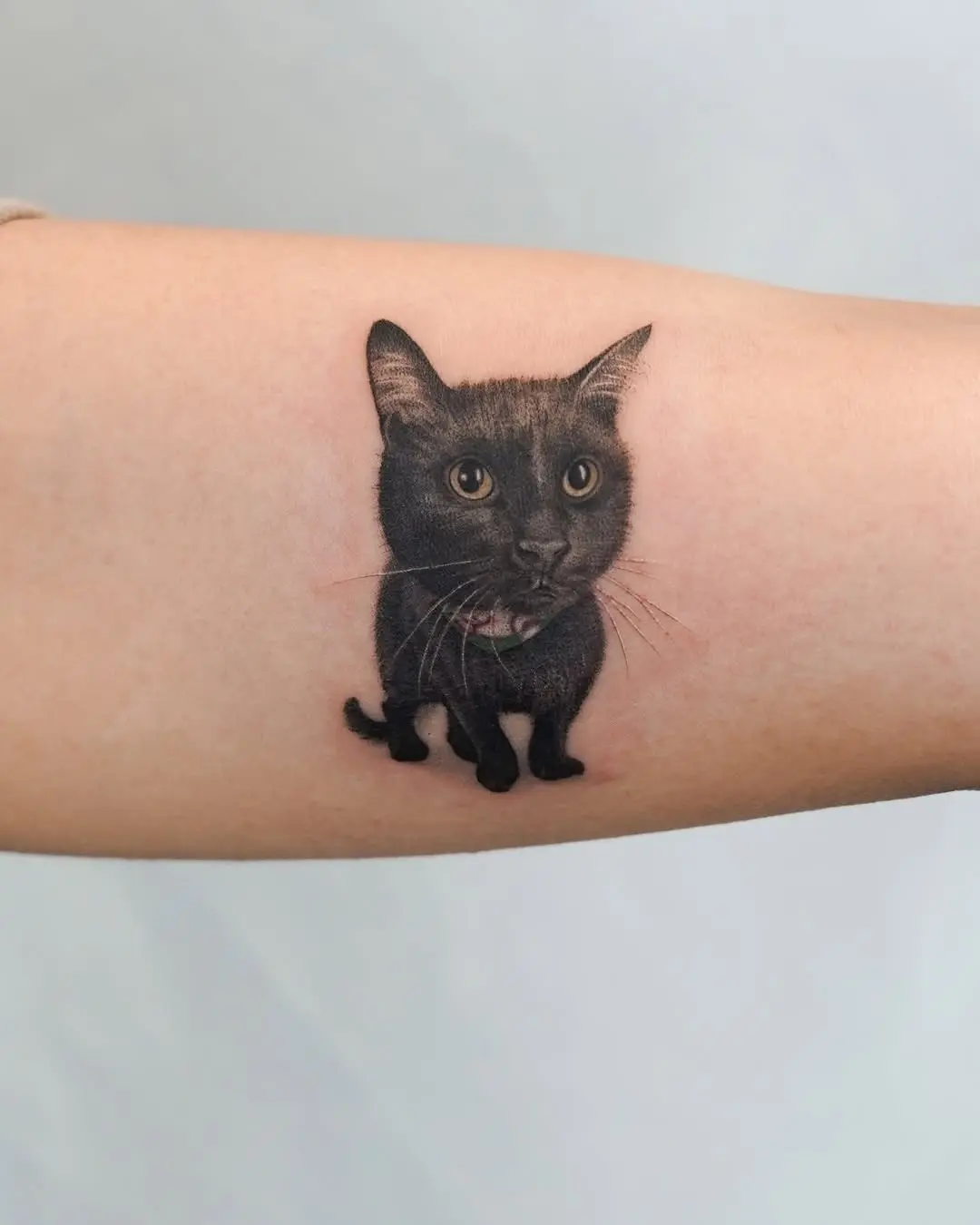 Whimsical black cat tattoo with realistic details